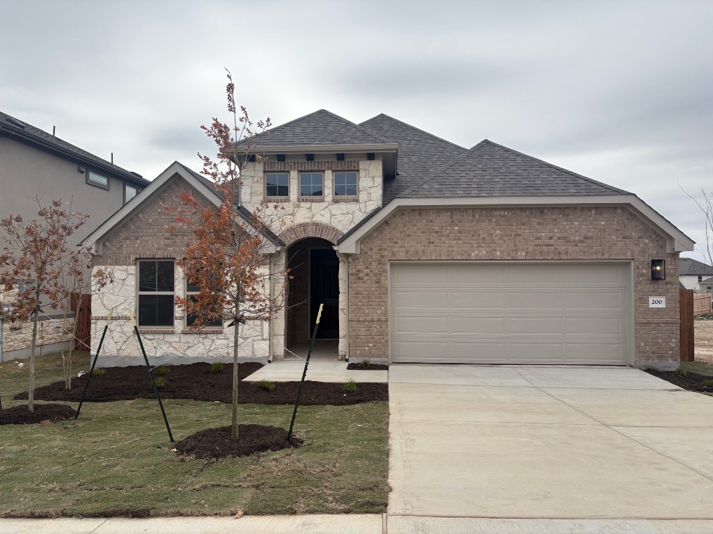 French provincial home with an attached garage, driveway, a shingled roof, and stone siding