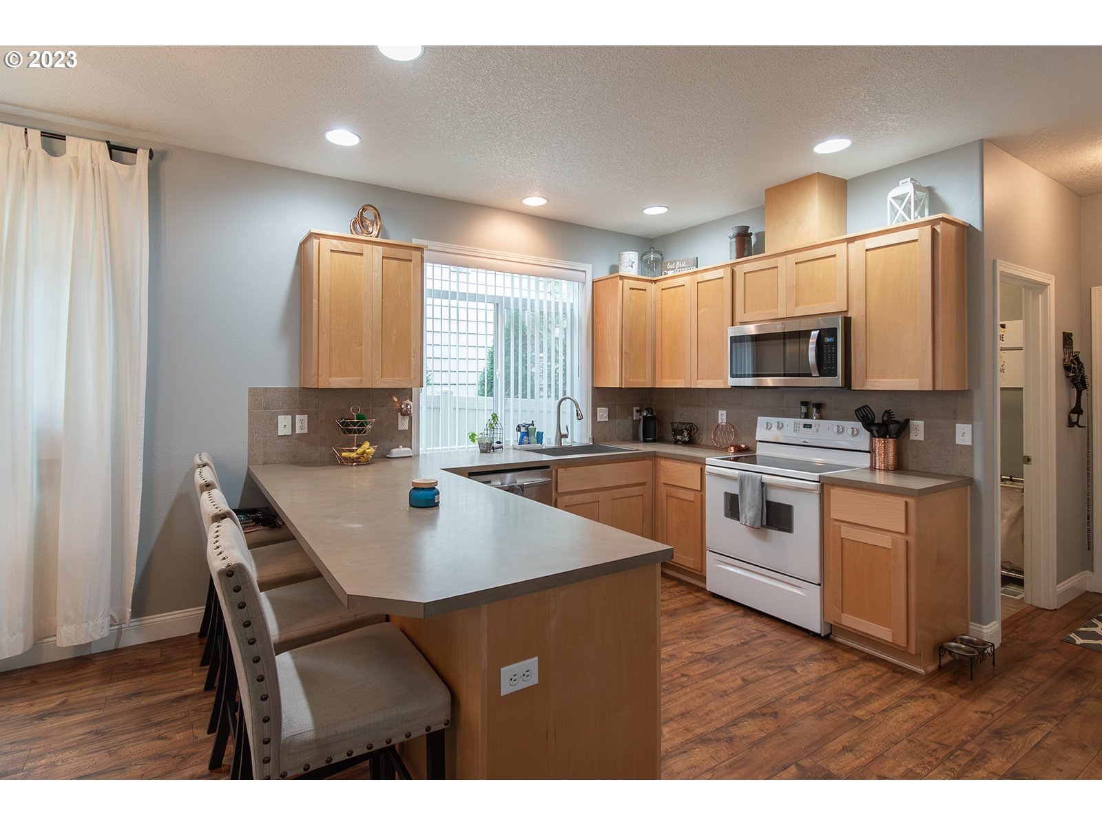 3148 South 3rd Way Ridgefield, WA 98642 - Photo 10 of 27 a kitchen with white cabinets a sink stove and refrigerator