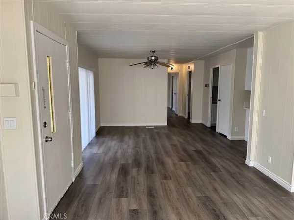 a view of a hallway with wooden floor and a ceiling fan