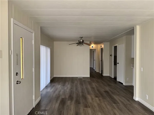 a view of a room with wooden floor and a ceiling fan