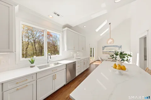 a large white kitchen with a large window
