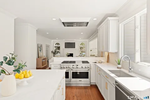 a kitchen with stainless steel appliances a stove sink and white cabinets