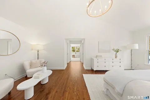 a spacious bedroom with a bed and a chandelier
