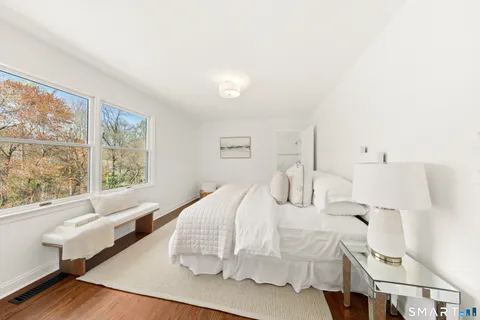 a bedroom with furniture and a large window