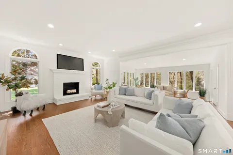 a living room with furniture a fireplace and a flat screen tv
