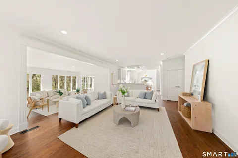 a living room with furniture large mirror and a flat screen tv
