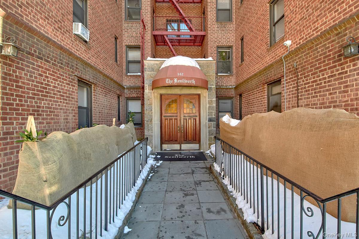 142 Garth Road, Unit 2M Scarsdale, NY 10583 - Photo 11 of 12 a view of a brick house with large windows