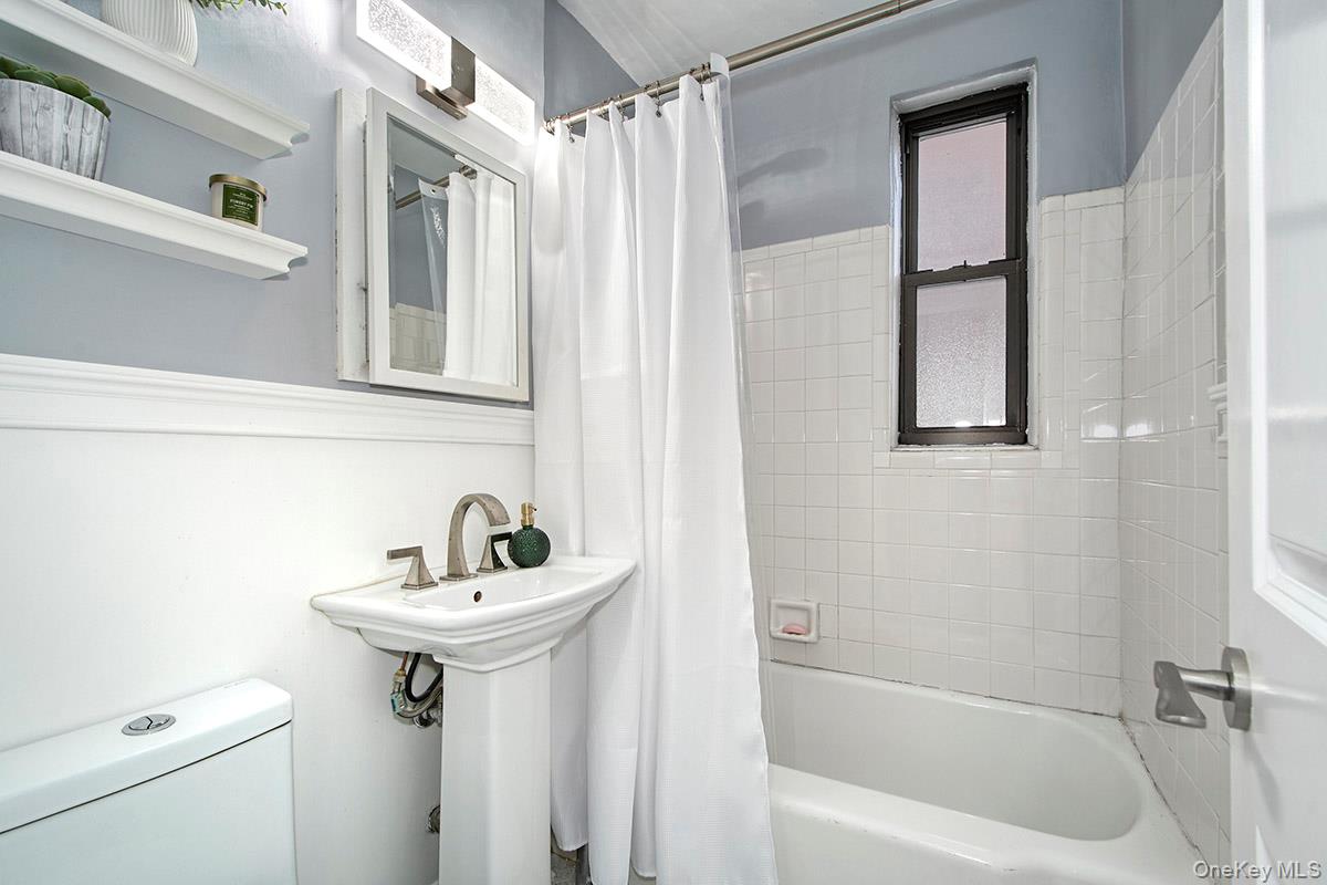 142 Garth Road, Unit 2M Scarsdale, NY 10583 - Photo 7 of 12 a bathroom with a sink a bathtub and a window