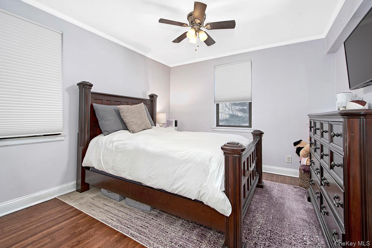 142 Garth Road, Unit 2M Scarsdale, NY 10583 - Photo 8 of 12 a bedroom with furniture and a flat screen tv