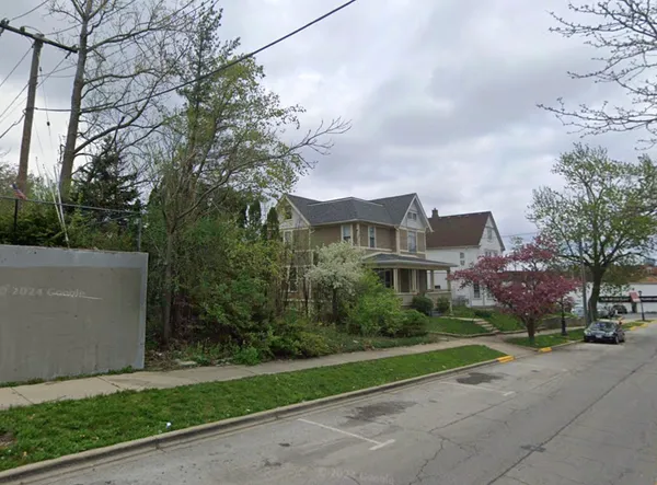 a view of a street with a house in the background