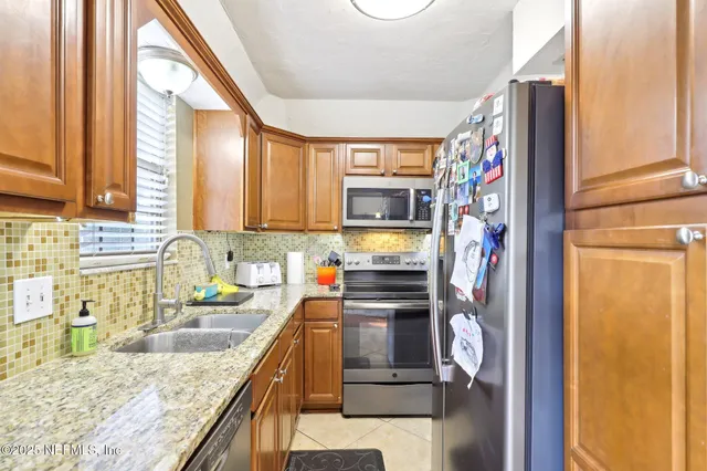 a kitchen with granite countertop a sink appliances and cabinets