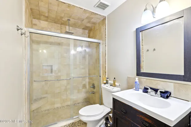 a bathroom with a sink toilet vanity and shower