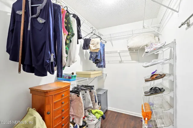 a view of walk in closet with clothes and shoes