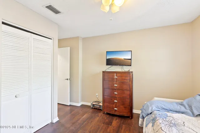 a bedroom with a bed and wooden floor