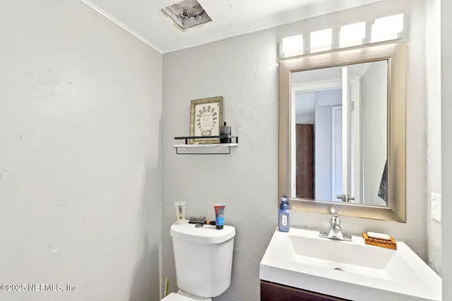 a bathroom with a toilet a sink and mirror
