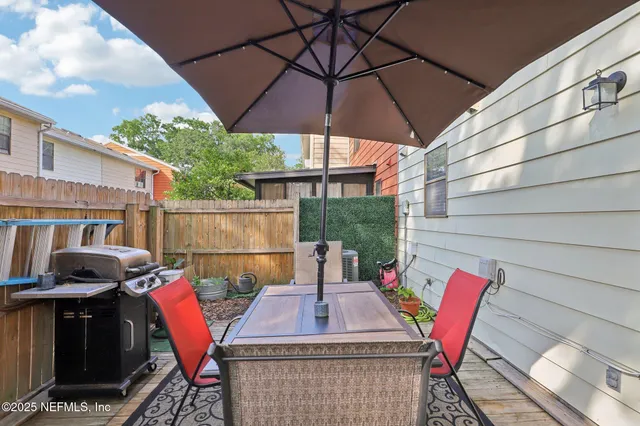 an outdoor sitting area with furniture and umbrella