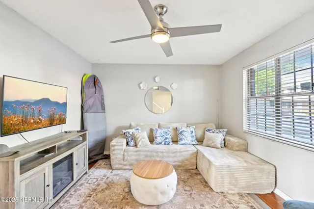 a living room with furniture a rug and a flat screen tv