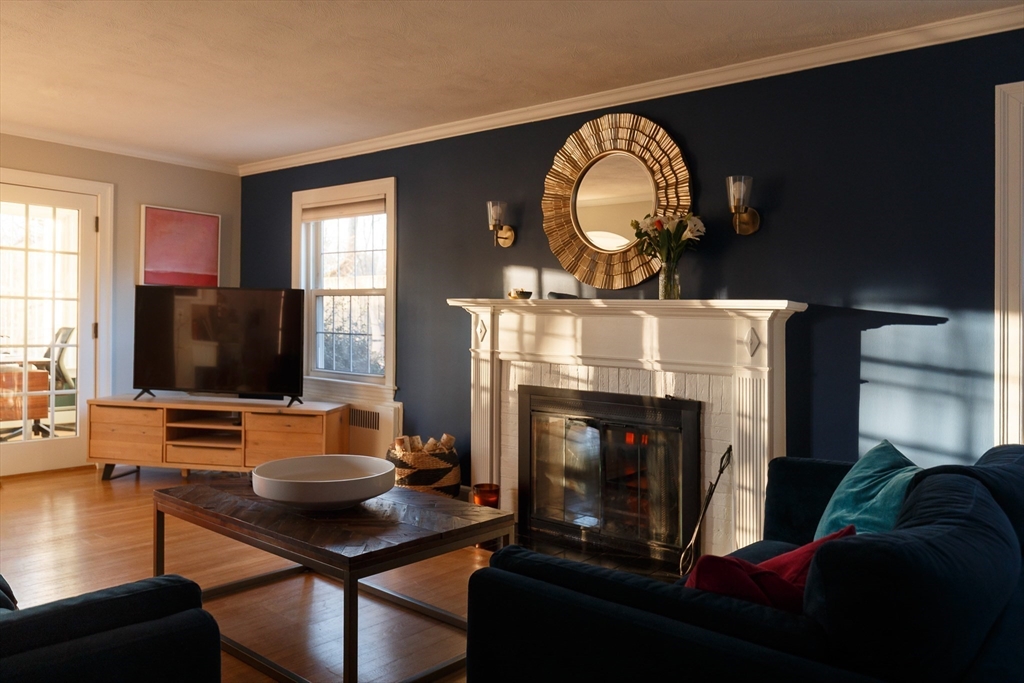 23 Regina Road Newton, MA 02466 - Photo 12 of 33 a living room with furniture a flat screen tv and a fireplace