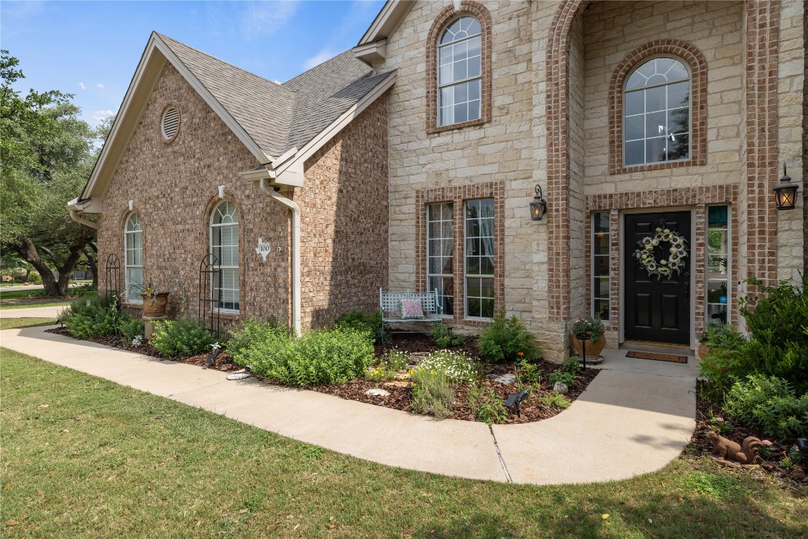 100 South Ridge Circle Georgetown, TX 78628 - Photo 2 of 37 View of front of home with brick siding, a shingled roof, stone siding, and a front lawn