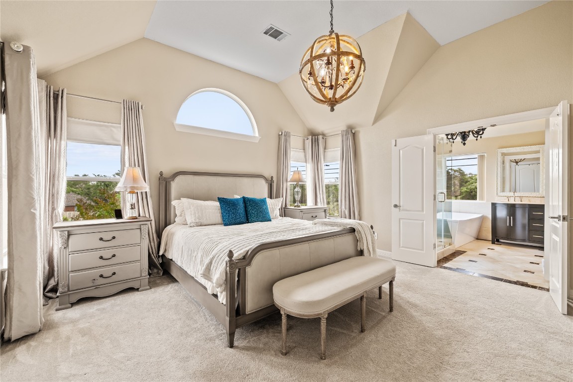 100 South Ridge Circle Georgetown, TX 78628 - Photo 25 of 37 Carpeted bedroom featuring visible vents, ensuite bath, a chandelier, and vaulted ceiling