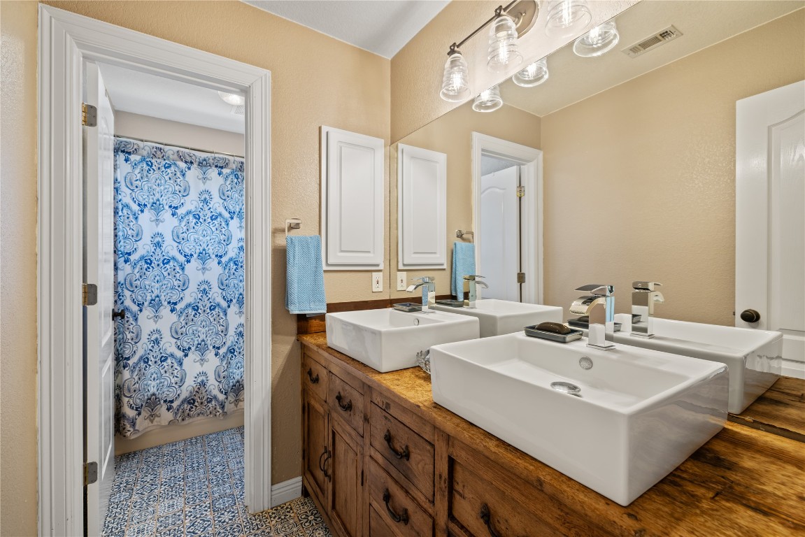 100 South Ridge Circle Georgetown, TX 78628 - Photo 32 of 37 Bathroom featuring double vanity, visible vents, and a sink