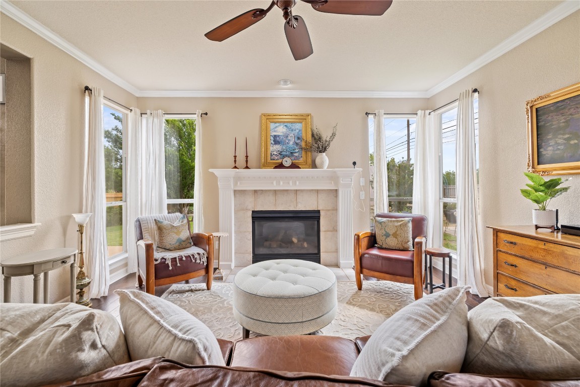 100 South Ridge Circle Georgetown, TX 78628 - Photo 6 of 37 Living room with crown molding, a ceiling fan, and a healthy amount of sunlight