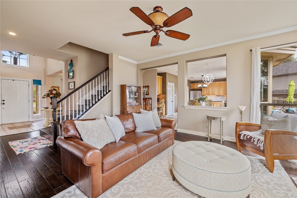 100 South Ridge Circle Georgetown, TX 78628 - Photo 8 of 37 Living room featuring stairs, baseboards, hardwood / wood-style flooring, and ceiling fan with notable chandelier