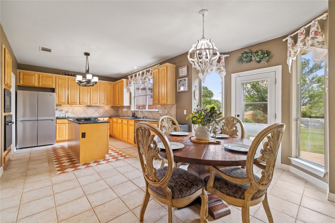 100 South Ridge Circle Georgetown, TX 78628 - Photo 9 of 37 Dining room featuring light tile patterned flooring, an inviting chandelier, and visible vents