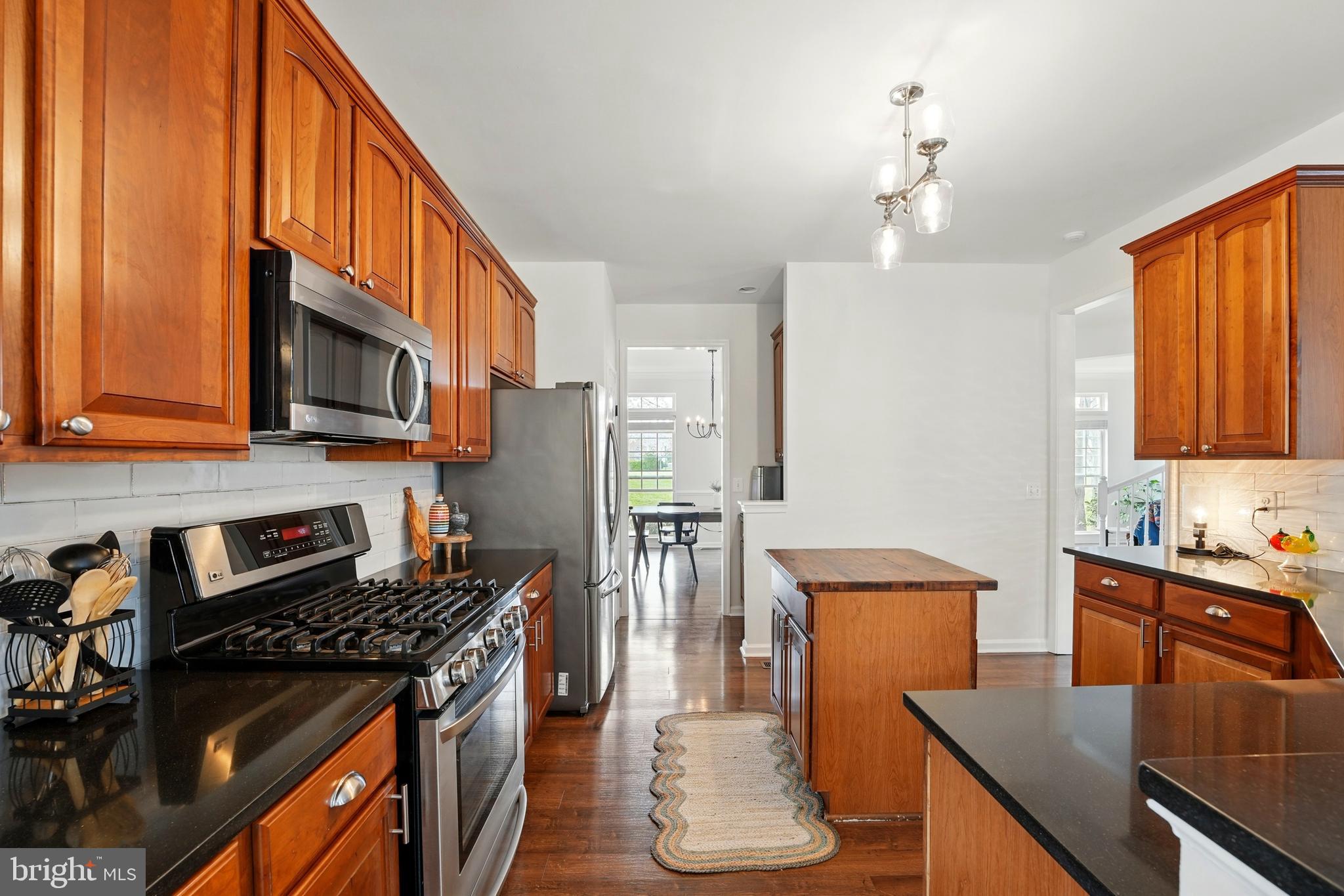 6712 Eldermill Lane Gainesville, VA 20155 - Photo 16 of 56 a kitchen with stainless steel appliances a stove a sink dishwasher and a refrigerator