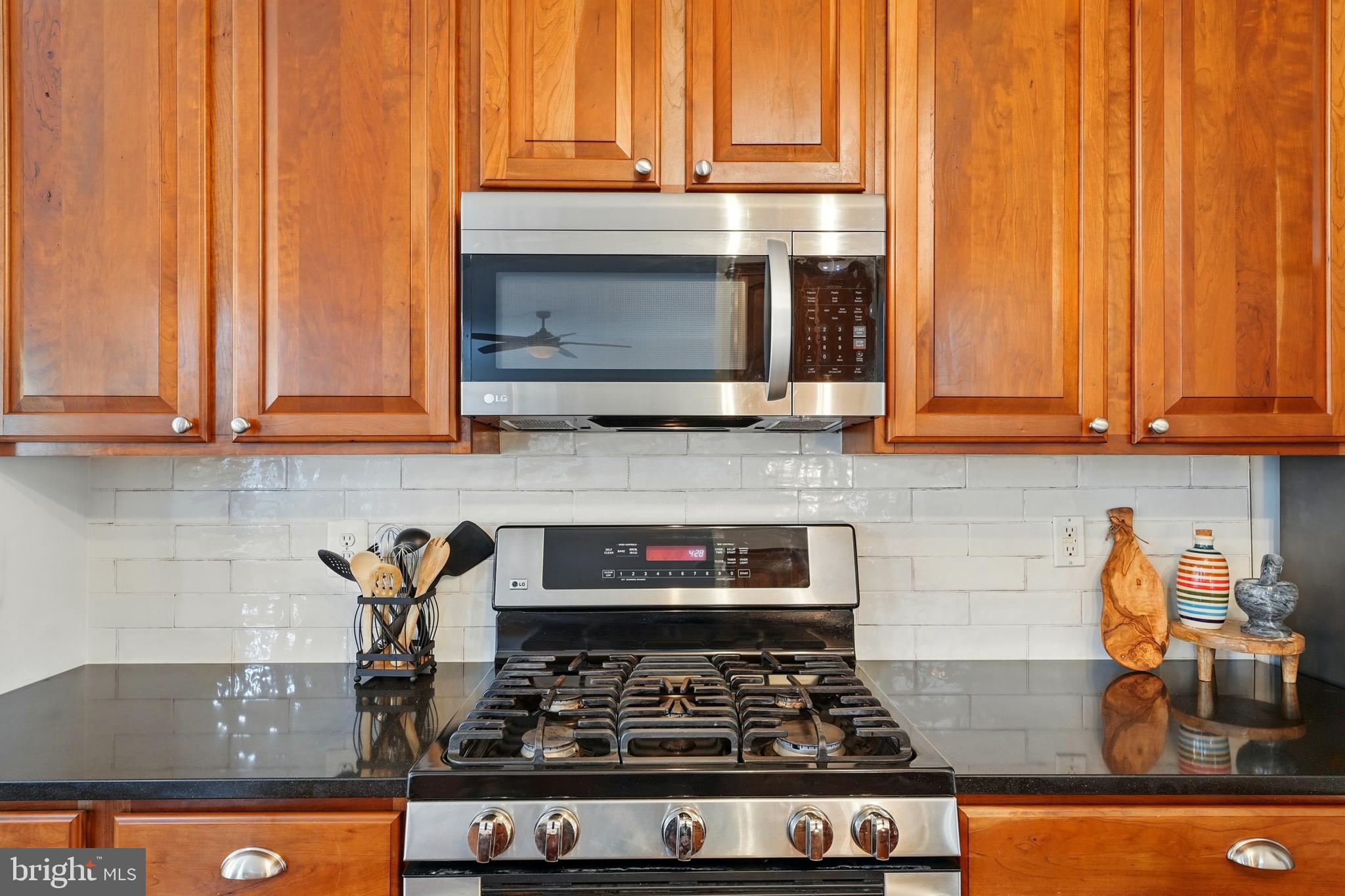 6712 Eldermill Lane Gainesville, VA 20155 - Photo 17 of 56 a kitchen with stainless steel appliances granite countertop a stove and a microwave