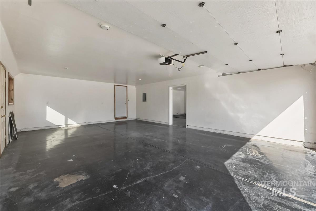 2804 West Sunrise Rim Road Boise, ID 83705 - Photo 50 of 50 Spacious garage featuring a concrete floor, white painted walls, and a visible garage door opener mechanism