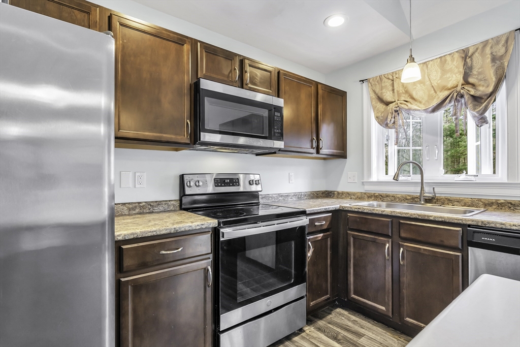 1 Lois Lane Townsend, MA 01469 - Photo 13 of 38 a kitchen with stainless steel appliances granite countertop a sink stove and refrigerator