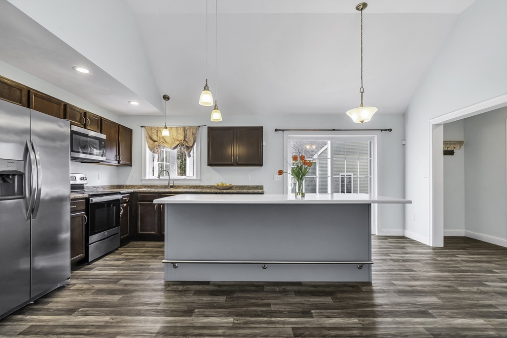 1 Lois Lane Townsend, MA 01469 - Photo 8 of 38 a kitchen with stainless steel appliances granite countertop a refrigerator a stove a microwave oven a sink with wooden floor and cabinets