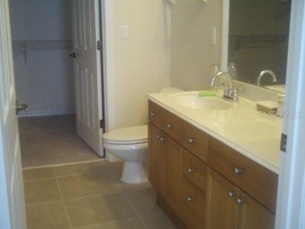 8168 Boat Hook Loop, Unit 202 Windermere, FL 34786 - Photo 2 of 5 a bathroom with a granite countertop sink a toilet and a mirror