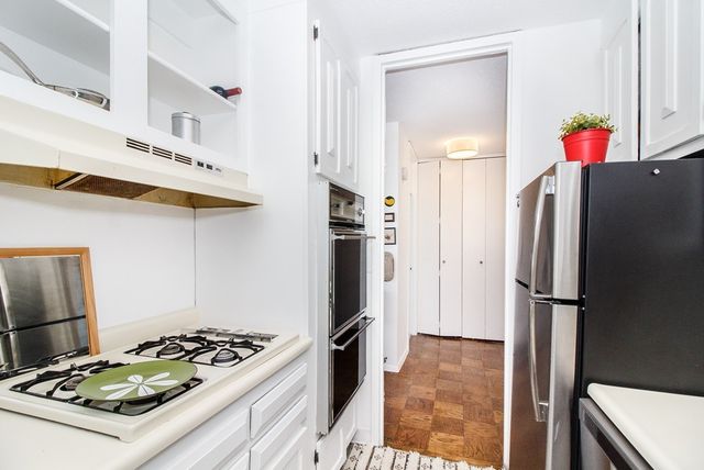 a kitchen with stainless steel appliances granite countertop a refrigerator and a stove