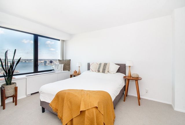 a spacious bedroom with a bed and large windows