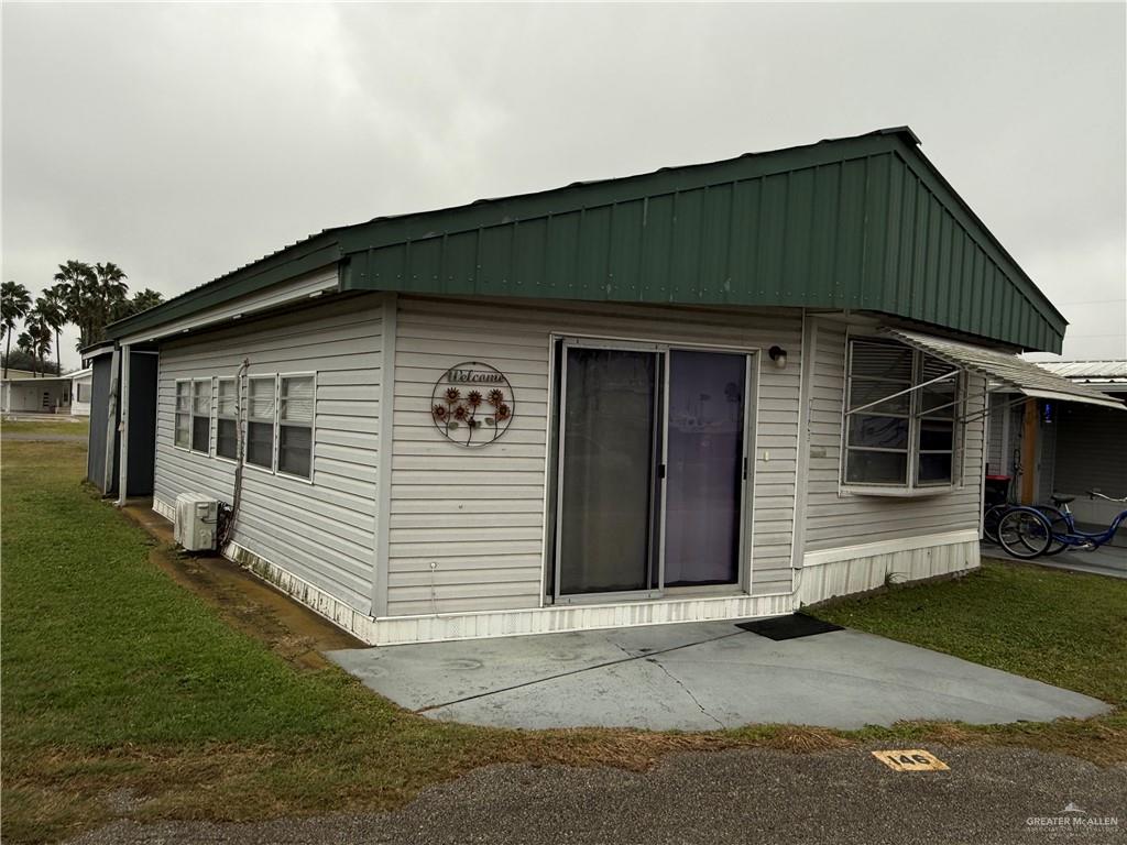 View of front of house featuring a patio, a front lawn, and a carport