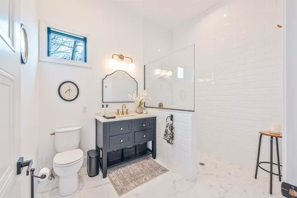 a spacious bathroom with a toilet a sink and a mirror