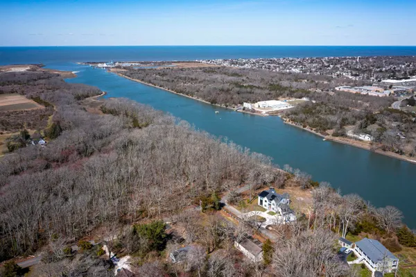 an aerial view of ocean and residential houses with outdoor space