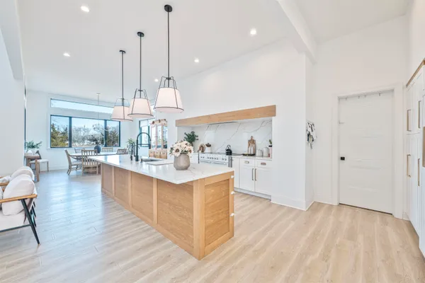 a view of kitchen with kitchen island stainless steel appliances wooden floor and living room view
