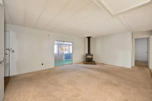 a large kitchen with granite countertop a sink and white cabinets