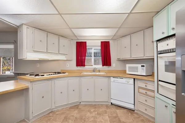 a kitchen with stainless steel appliances granite countertop a refrigerator a sink dishwasher a stove with wooden cabinets
