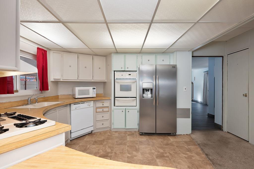 2874 Hidden Springs Circle Placerville, CA 95667 - Photo 26 of 41 a kitchen with stainless steel appliances granite countertop a refrigerator a sink dishwasher a stove with wooden cabinets