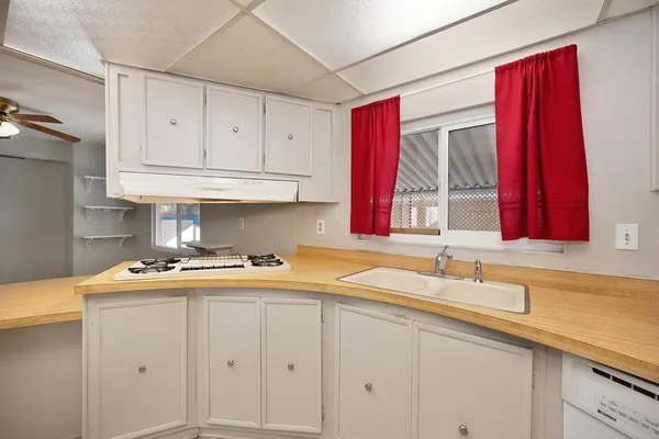 a view of a kitchen with a sink and a chandelier fan