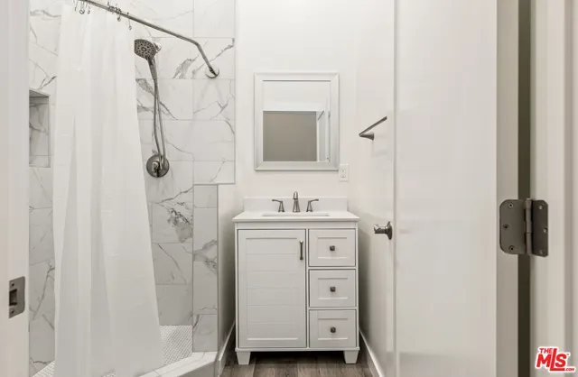 a bathroom with a sink a mirror a vanity and a shower