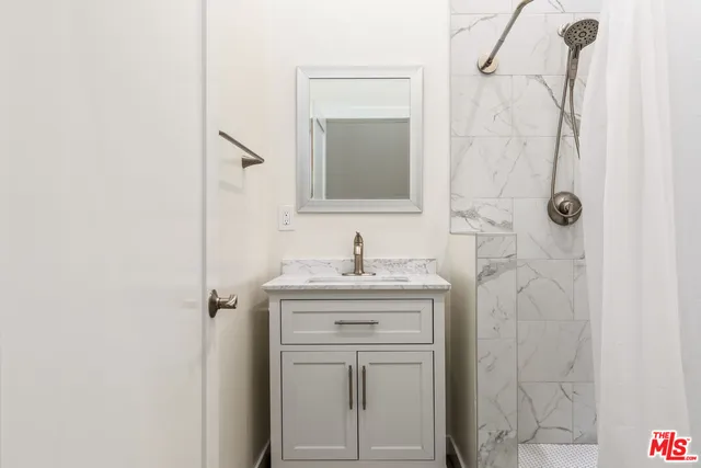 a bathroom with a granite countertop sink a toilet and shower