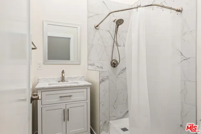 a bathroom with a granite countertop sink a shower and a mirror