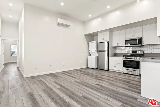 a view of kitchen with refrigerator microwave and stove top oven