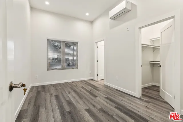 a view of a room with wooden floor and a ceiling fan