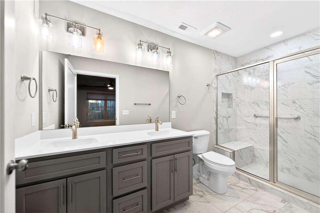 734 Sandstone Way Rostraver Township, PA 15012 - Photo 27 of 50 The primary bathroom is located inside the primary bedroom. It offers the convenience of a double sink, accessible grab bars and exquisite Calcutta Marble on the shower walls and bathroom floor.